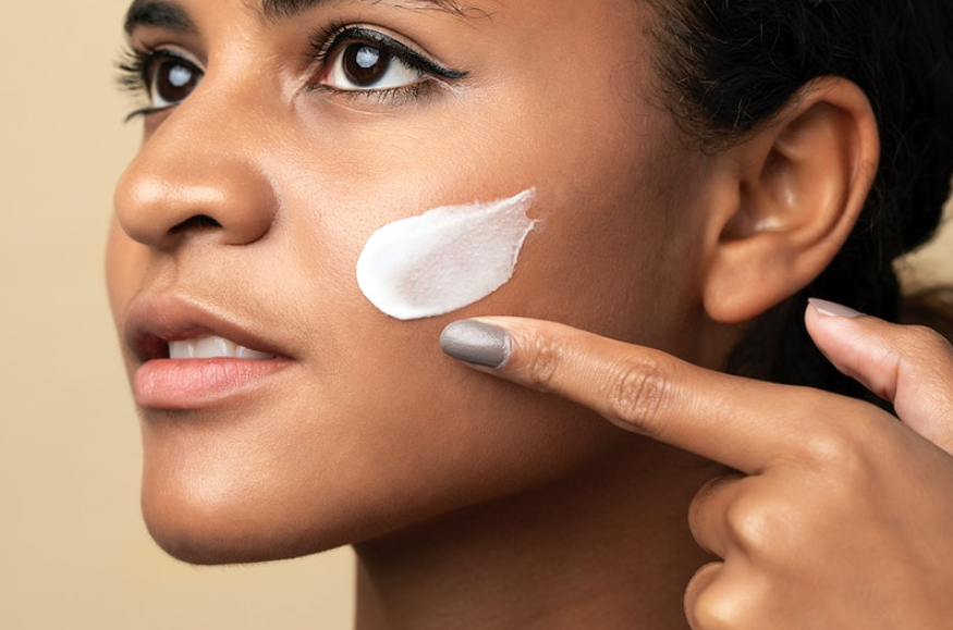 woman applying moisturizer in her face